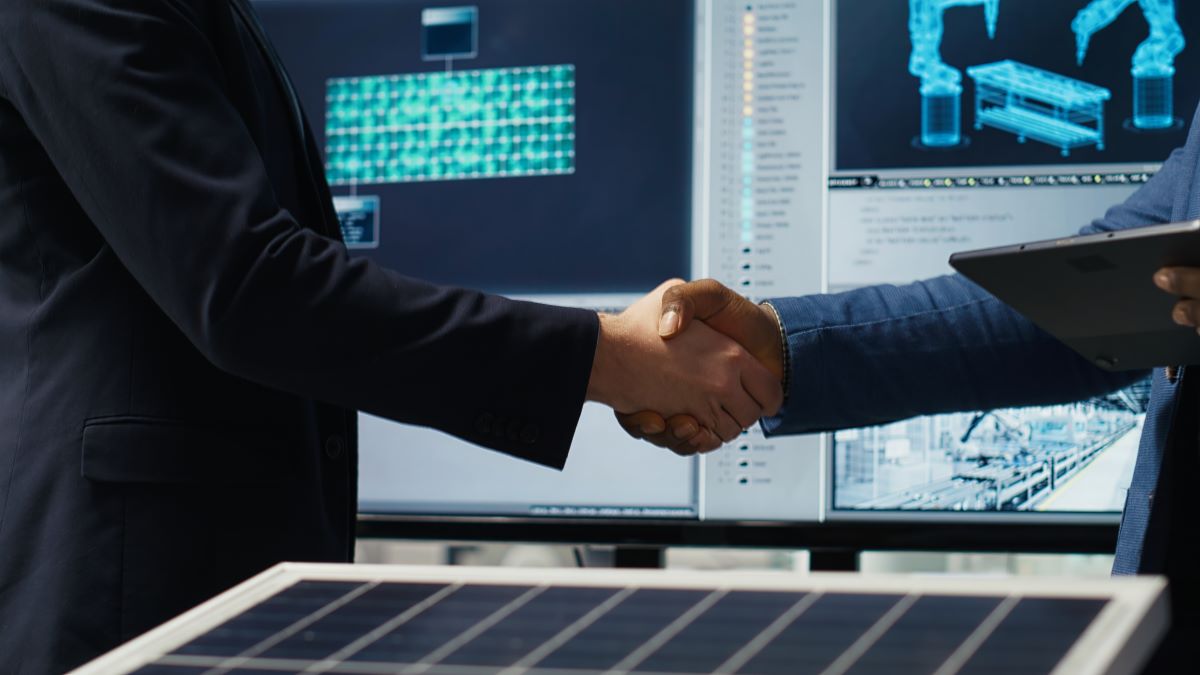 Factory manager shakes hands with investor working expand production
