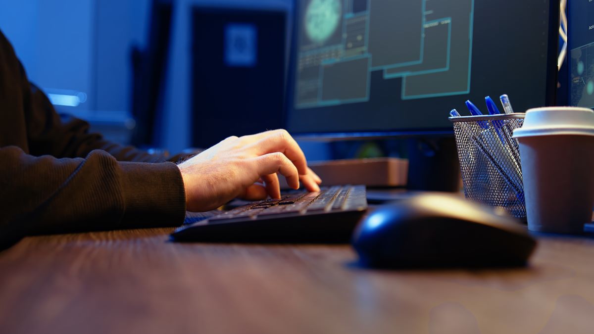 Meticulous hacker typing computer keyboard close up